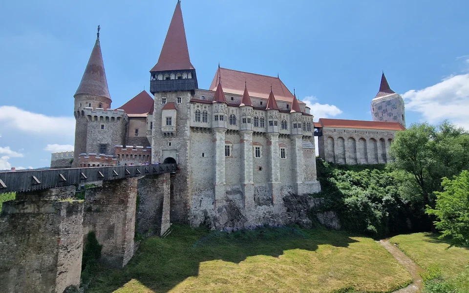 Corvin Castle above Hunedoara, its red-roofed towers and timber bridge rising from the rock