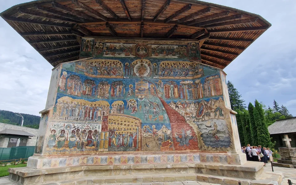 The Last Judgement fresco across the west wall of Voroneț Monastery, under its wide eaves